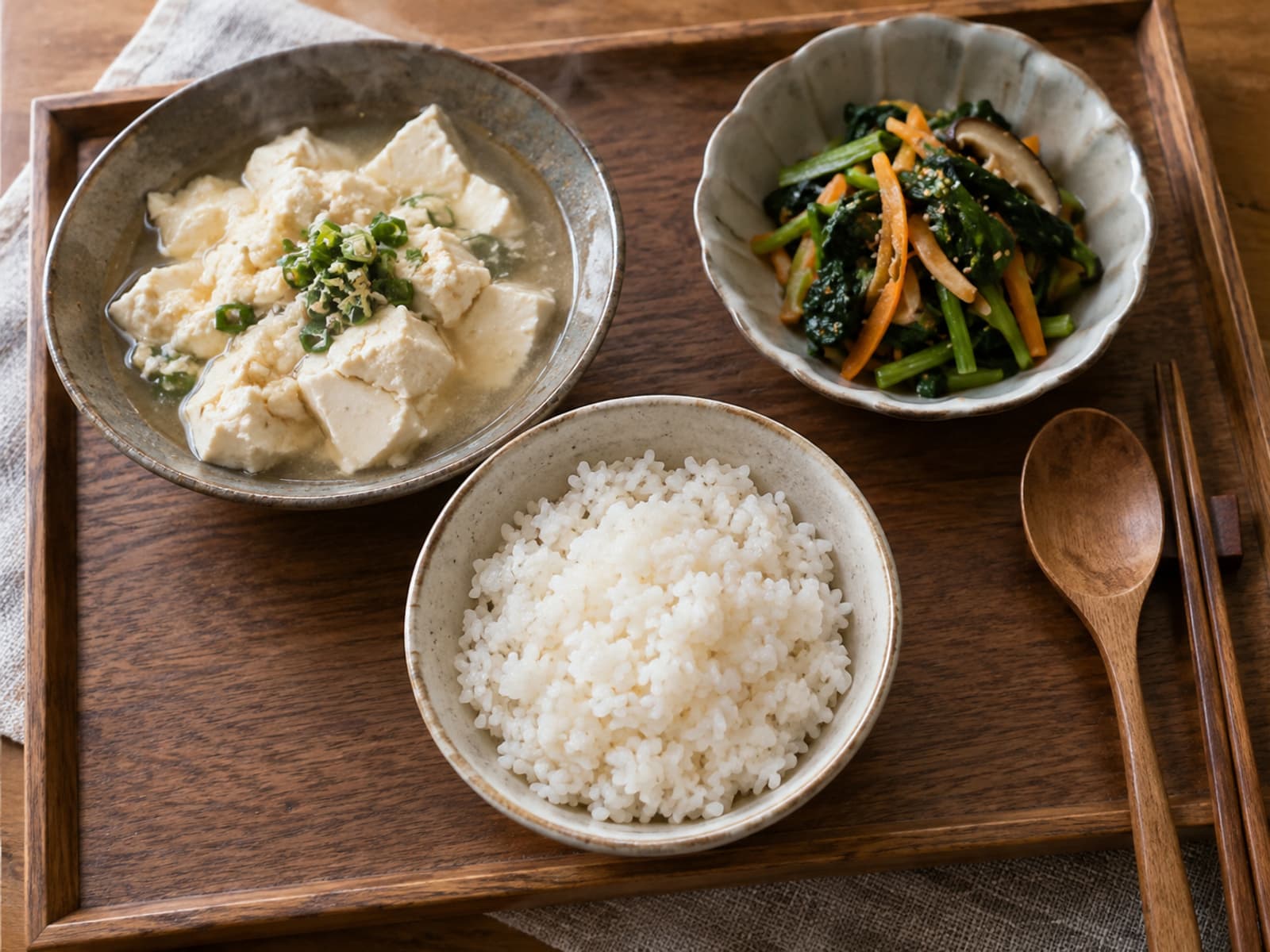 밥과 익힌 두부, 채소 반찬을 작은 쟁반에 차린 모습