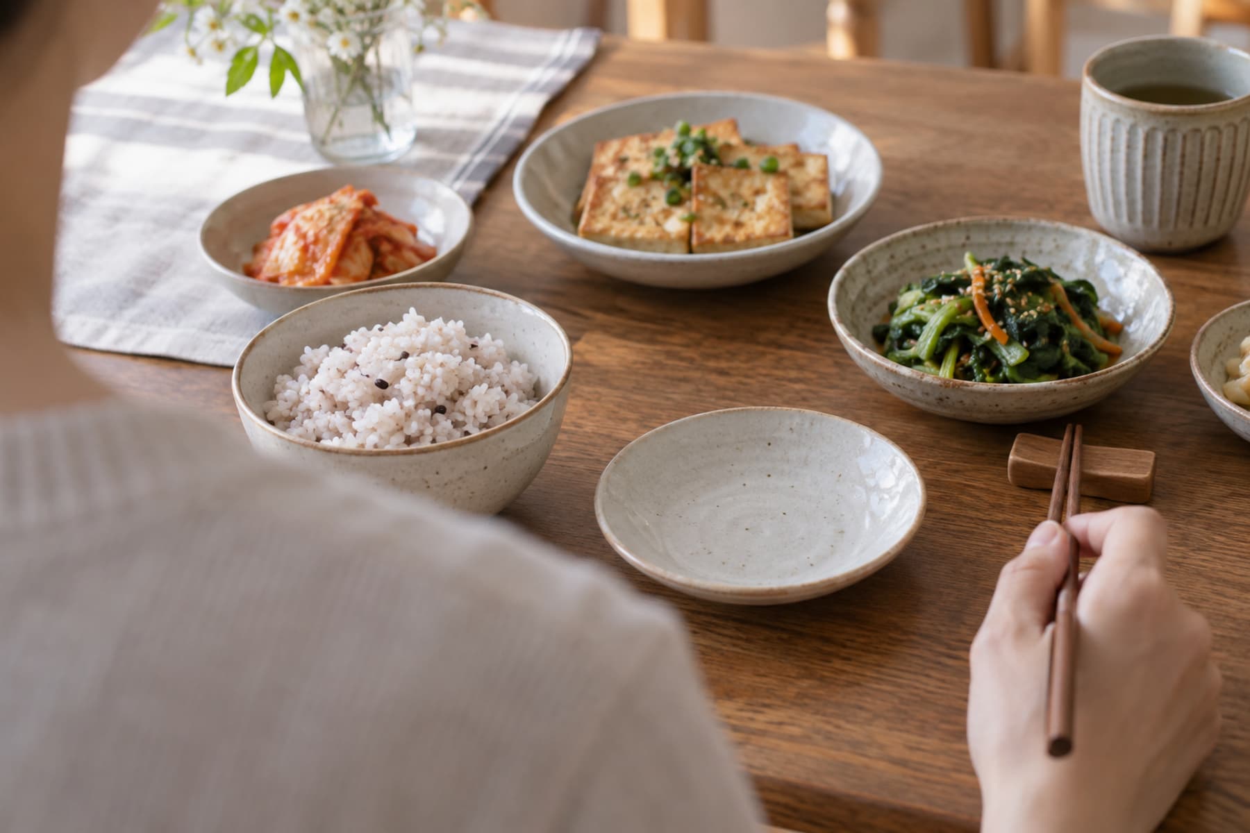 주식과 반찬 사이에 빈 접시가 놓인 가정식 식탁.
